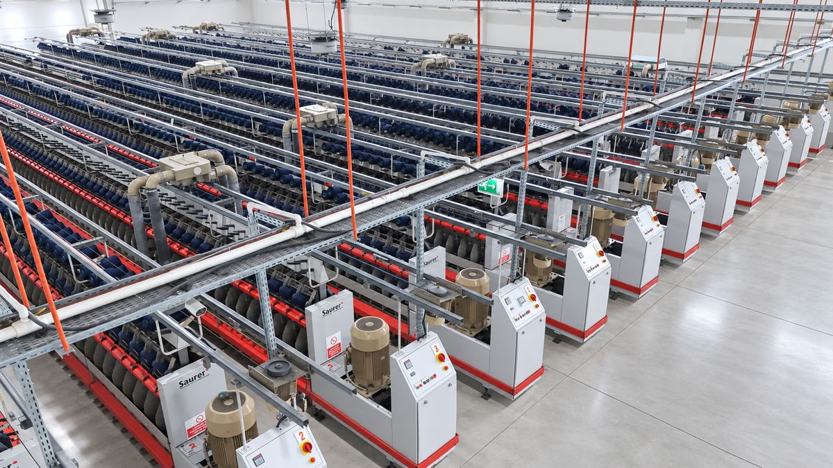 Üretim salonunda sıra hâlinde büküm makineleri, yüksek açıdan